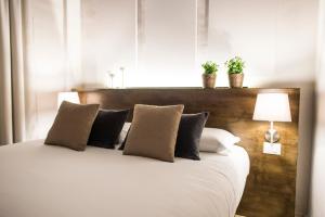 Un dormitorio con una gran cama blanca con dos plantas. en Palazzo del Papa en Siena