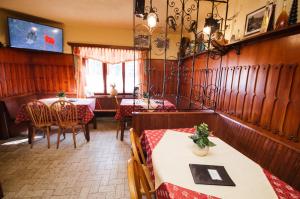 a restaurant with two tables and chairs and a television at Guesthouse & Restaurant Brišar 1898 in Grahovo