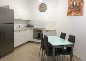 eine Küche mit einem Tisch und Stühlen sowie einem Kühlschrank in der Unterkunft Saidoff Luxury Residence in Jerusalem