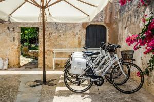 due biciclette parcheggiate sotto un ombrellone accanto a un edificio di Badia del Casale a Ugento