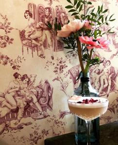 a vase with a flower and a drink on a table at Hôtel Le G (ex Le Genève) in Nice