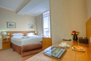 a hotel room with a bed and a table at City Hotel Bishkek in Bishkek +42 photos