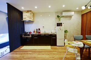 a kitchen with a white refrigerator and a table at Yamato Family House - 2 Floors | 3 bedrooms in Osaka