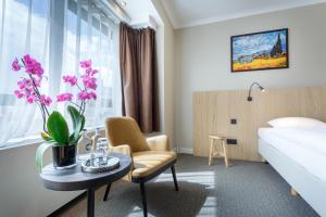 a hotel room with a bed and a table and a chair at Hotel Carlton in Ghent
