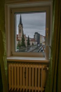 ein Fenster mit einem Heizkörper und Blick auf eine Kirche in der Unterkunft Flataid Apartment Elisabethinergasse in Graz