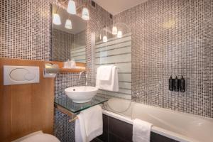 a bathroom with a sink and a toilet and a tub at Hotel Carlton in Ghent
