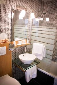 a bathroom with a sink and a shower at Hotel Carlton in Ghent