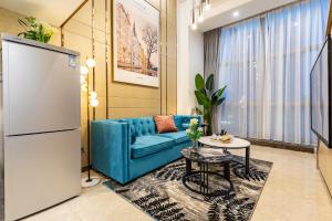 a living room with a blue couch and a table at Livetour Hotel Zhujiang New Town Guangzhou in Guangzhou