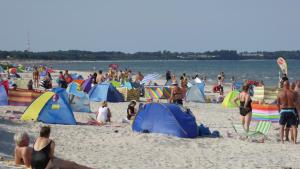 eine Gruppe von Menschen am Strand mit Zelten in der Unterkunft Ferienhaus Gut Rattelvitz Insel Rügen in Gingst