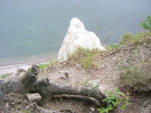 una roca sentada en la cima de una colina junto al agua en Ferienhaus Gut Rattelvitz Insel Rügen, en Gingst