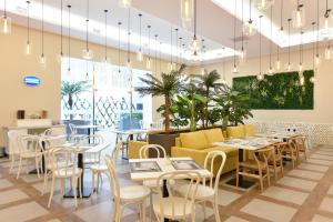 a restaurant with tables and chairs and potted plants at EXE Wellington in Figueira da Foz