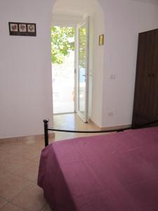 a bedroom with a bed and an open door at Le Case dei Pescatori - Albicocco in Ponza