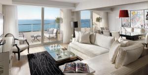 a living room with a white couch and a view of the ocean at Divani Apollon Palace & Thalasso in Athens