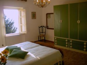 a bedroom with a bed and a green cabinet at Cascina tra i vigneti a Nizza Monferrato in Nizza Monferrato