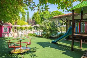 a playground with a slide and a table and chairs at Park Residence Il Gabbiano in Moniga
