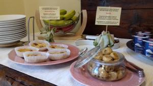 a table topped with plates of donuts and cupcakes at Agriturismo Otto Ducati D'Oro in Isola della Scala