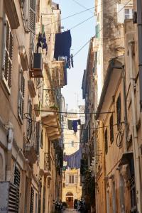an alley in an old town with clotheslines at Old Town Luxury Suites 'Lady' in Corfu