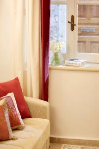 een woonkamer met een bank en een raam bij Old Town Luxury Suites 'Lady' in Corfu-stad