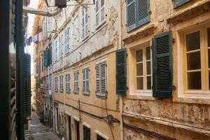 un vecchio edificio con persiane verdi su una strada di Old Town Luxury Suites 'Lady' a Città di Corfù