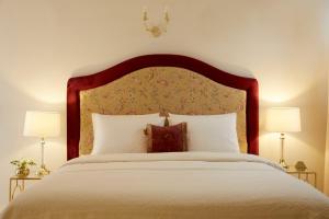 una camera da letto con un grande letto bianco con due lampade di Old Town Luxury Suites 'Lady' a Città di Corfù