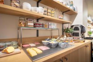 a counter with cheese and other food items on it at Hotel Carlton in Ghent