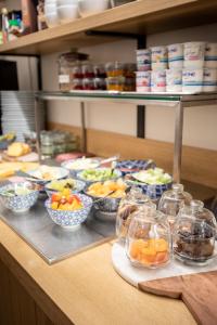 a buffet with bowls of fruit and other food on a counter at Hotel Carlton in Ghent