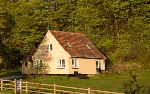 博雷Snowwhites House的一间白色的小房子,有红色的屋顶