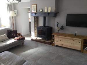a living room with a tv and a fireplace at The little house in Mézières-sur-Issoire