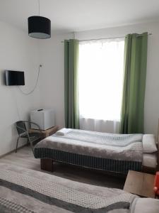 Un dormitorio con dos camas y una ventana. en Green House, en Bucarest