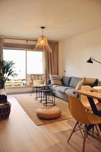 ein Wohnzimmer mit einem Sofa und einem Tisch in der Unterkunft Casa MODERNA con Terraza Chill Out - Estadio BERNABÉU in Madrid