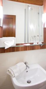 a bathroom with a white sink and a mirror at Gasthof und Pension zur Sonne in Schollbrunn