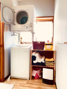 uma cozinha com um frigorífico e um micro-ondas em Ishimaru House em Seki