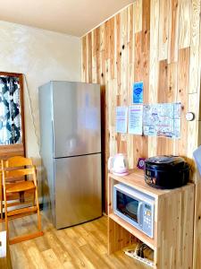 cocina con nevera y microondas en una encimera en Ishimaru House, en Seki