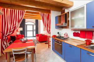 uma cozinha e sala de estar com uma mesa vermelha e cadeiras em Stella Marina 3 em Veneza