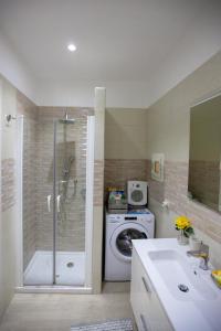 een badkamer met een douche en een wasmachine bij Garibaldi House Apartment in Napels