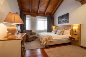 a bedroom with a bed and a desk with a lamp at Eira Ski Lodge in Baqueira-Beret