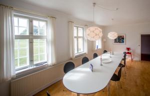 une salle de réunion avec une grande table et des chaises dans l'établissement Søndergård, à Borre