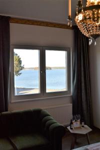 a living room with two windows and a couch at Hotell Wettern in Karlsborg