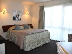 pokój hotelowy z łóżkiem i dużym oknem w obiekcie Cedar Grove Motor Lodge w mieście Nelson