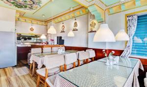 ein Esszimmer mit Tischen und Stühlen sowie eine Küche in der Unterkunft Dekeling Hotel in Darjeeling