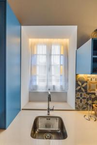 uma cozinha com um lavatório e uma janela em Azaleas Guest House em Ribeira Chã