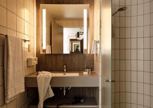 a bathroom with a sink and a mirror at Comwell Borupgaard in Snekkersten