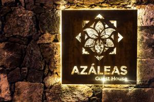 een teken voor een zoektocht huis op een stenen muur bij Azaleas Guest House in Ribeira Chã