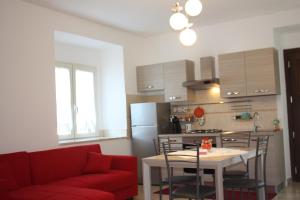 een keuken met een rode bank en een tafel met stoelen bij Appartamenti da Anna in Montaquila