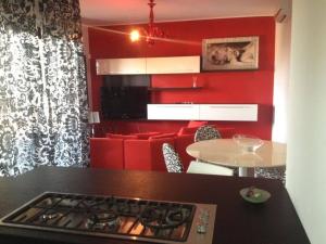 a kitchen with a stove and a red wall at Le Palme Residenza Estiva in Martinsicuro
