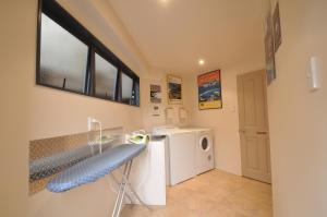 a laundry room with a washer and dryer at Bay Cabinz Motel in Paihia