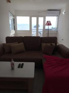 sala de estar con sofá marrón y mesa en Oro Apartments, en Petrovac na Moru