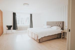 a white bedroom with a large bed and a window at The Light House in Borre