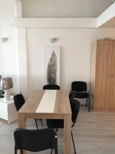 a dining room with a wooden table and chairs at Oro Apartments in Petrovac na Moru