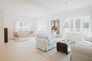 a white living room with a white couch and a table at The Light House in Borre